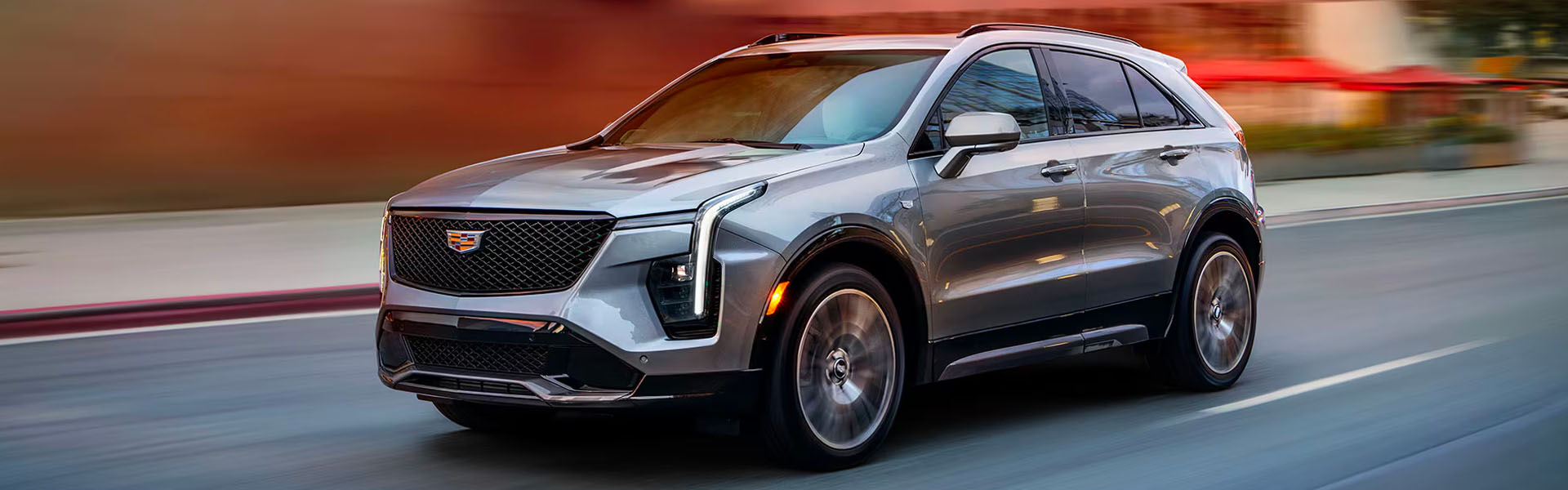 2025 Cadillac XT4 luxury compact SUV driving through a city street.