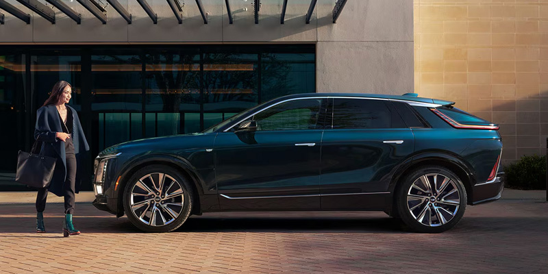 2026 Cadillac LYRIQ parked in front of a modern building, showcasing its sleek design and elegant features.